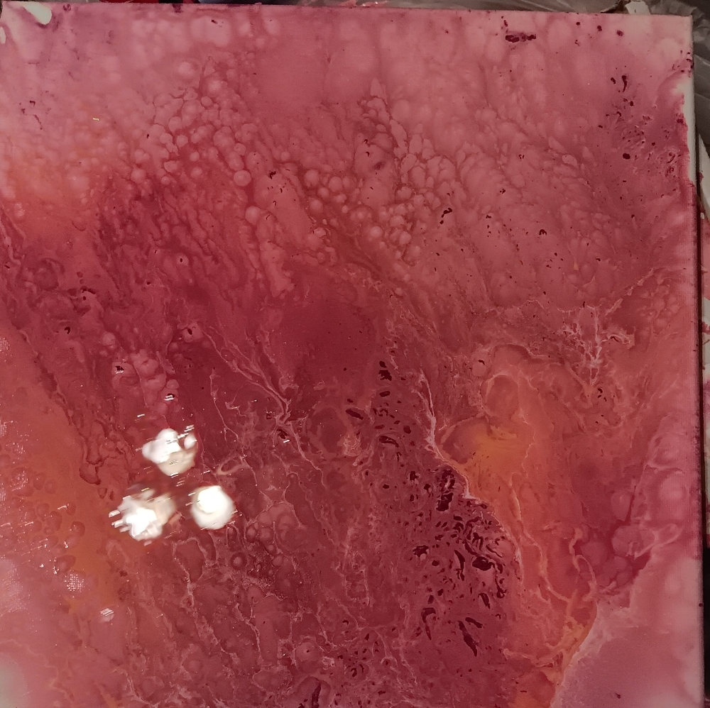 Different reds and pinks acrylic pour painting.